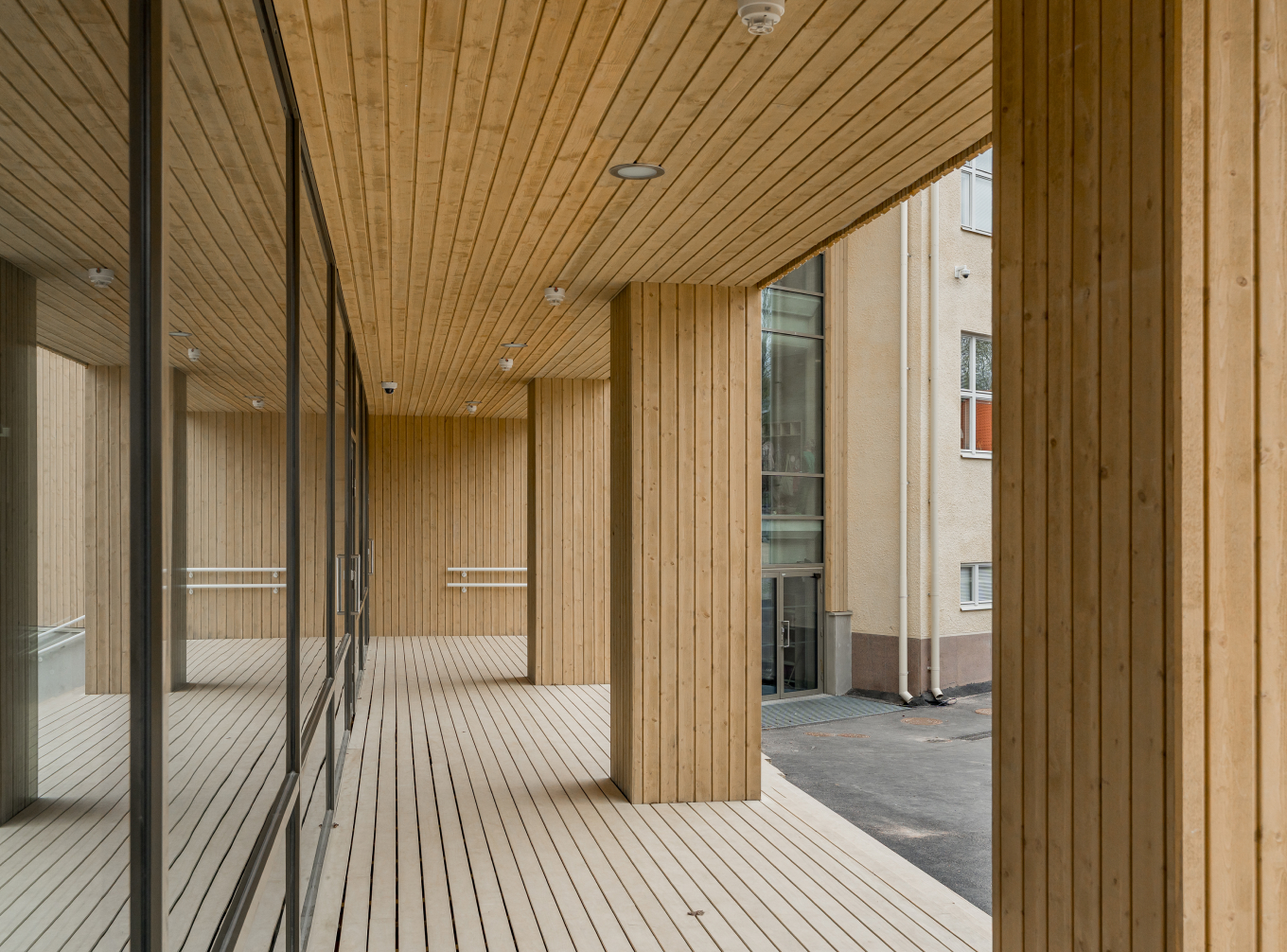 Main entrance of the new extension at Hoplaxskolan in Munkkiniemi with wood coated pillars.